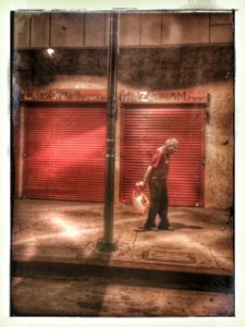 "Old Man Walking After Midnight, Downtown L.A" by Alexis Rhone Fancher.